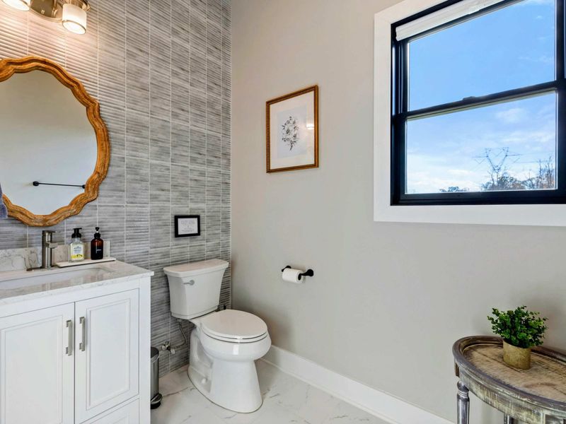 Half Bath (Main) - Modern vanity with vessel sink, mirror, and window overlooking the yard.