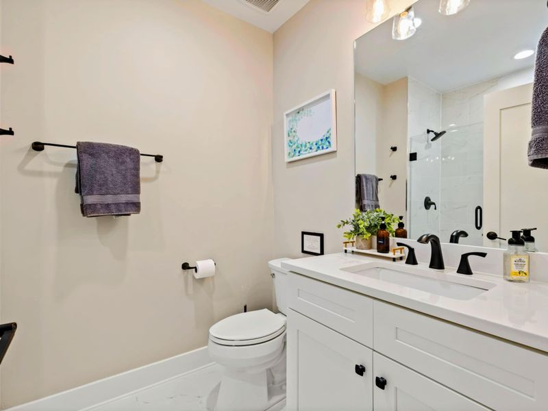 Bathroom 2 - Sleek vanity, elegant fixtures, and a glass-enclosed walk-in shower.