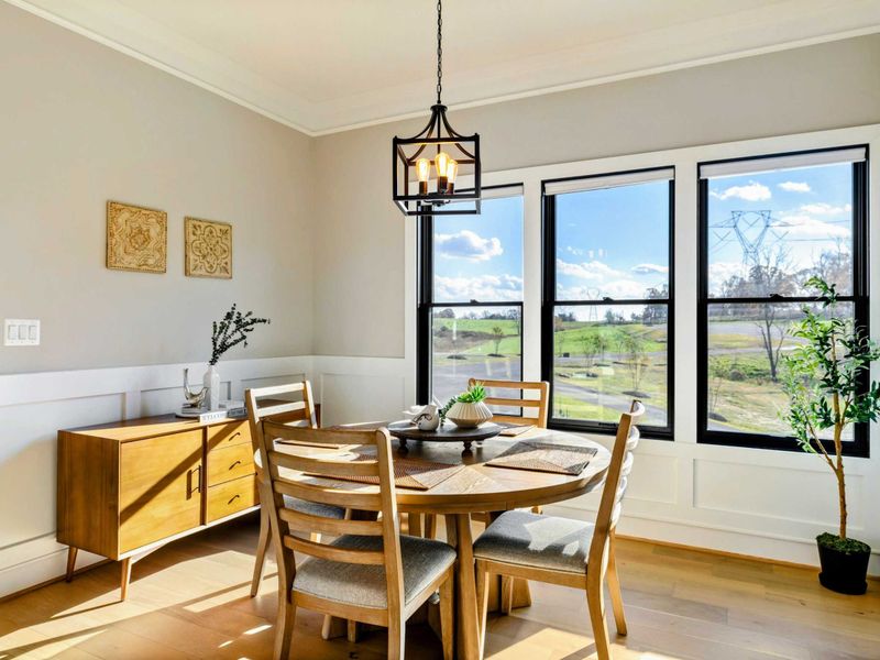 Kitchen - Breakfast nook with round table, decorative mirror, and garden views.