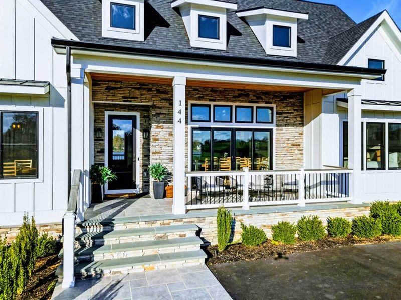 Exterior - Detail of the front entry with stone accents and landscaping.