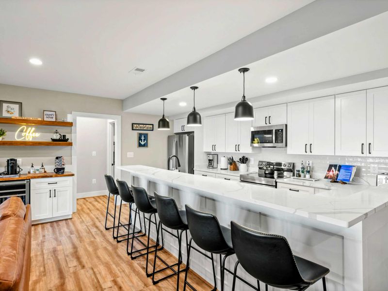 Lower Living Area - Marble-top kitchenette island with bar seating and pendant lights.