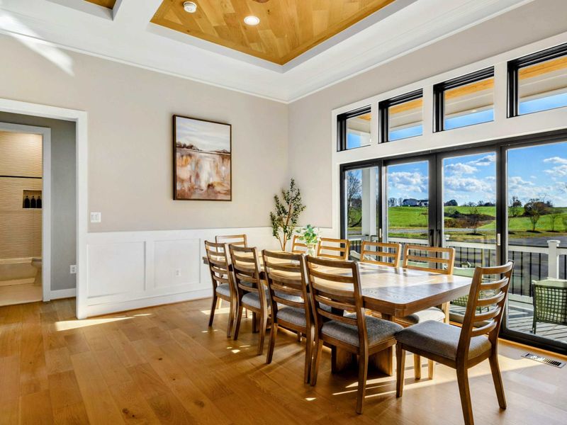 Great Room - Dining table for ten with high ceilings and lake-facing windows.