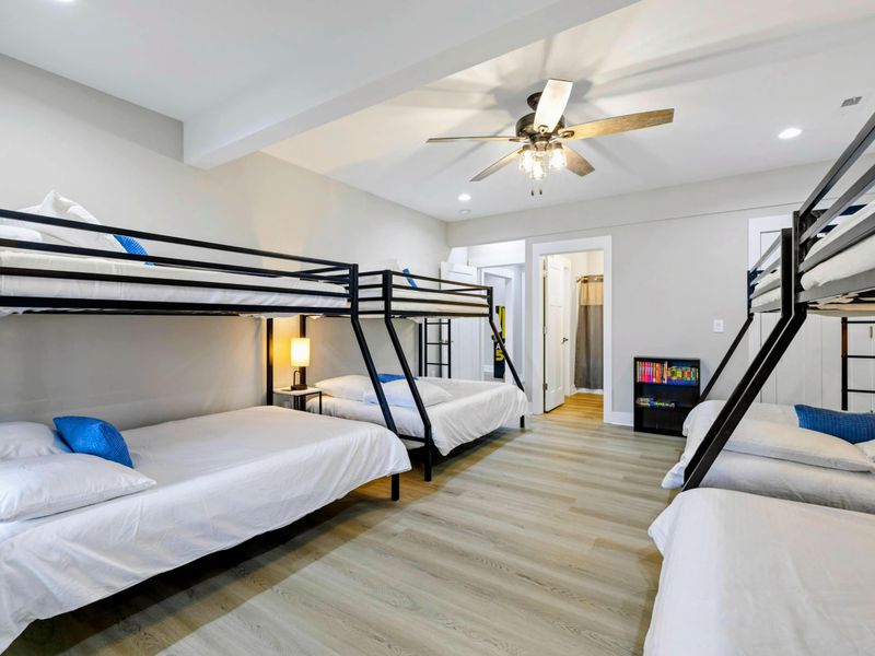 Spacious bunk room with multiple beds, ample sleeping accommodations, and an en suite bathroom, perfect for families or groups.