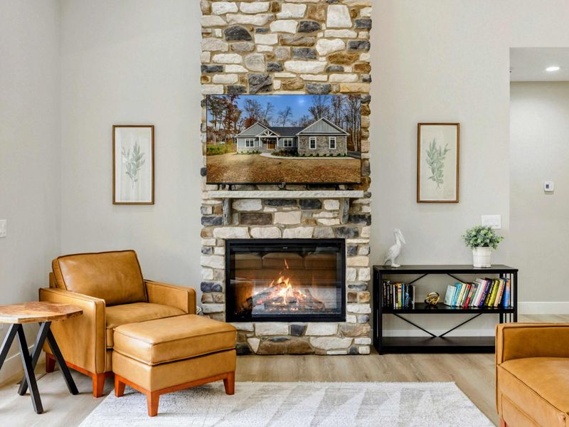 Cozy sitting area with a stone fireplace, leather armchairs, and tasteful decor, creating a warm and inviting atmosphere.