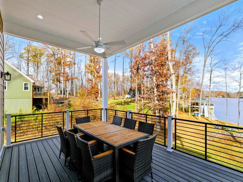 Elegant outdoor deck with a dining area, grill, cozy seating, and modern railings, perfect for entertaining or relaxing in style.