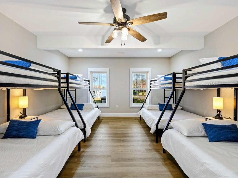 Spacious bunk room with multiple beds, ample sleeping accommodations, and an en suite bathroom, perfect for families or groups.
