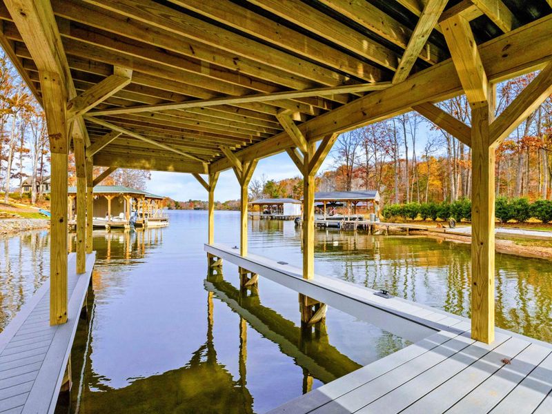 Spacious boat slip with wooden construction, offering direct access to the calm waters and surrounded by scenic natural views.