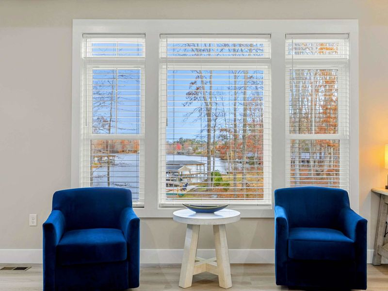 Elegant Primary Bedroom featuring a king-sized bed, stylish furnishings, a spacious layout, natural light from large windows, and an en suite bathroom for added convenience.
