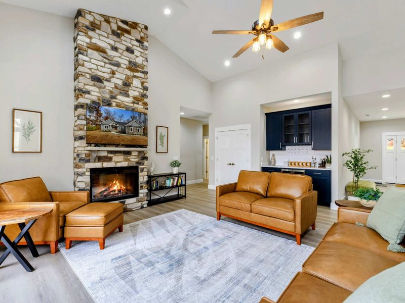 Open-concept living area featuring a cozy seating space, modern kitchen, and stylish wet bar, perfect for entertaining and relaxing.