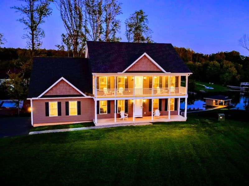 Exterior at Dusk - Warm glow through the windows, balconies stacked, the quiet of the private side settling in.