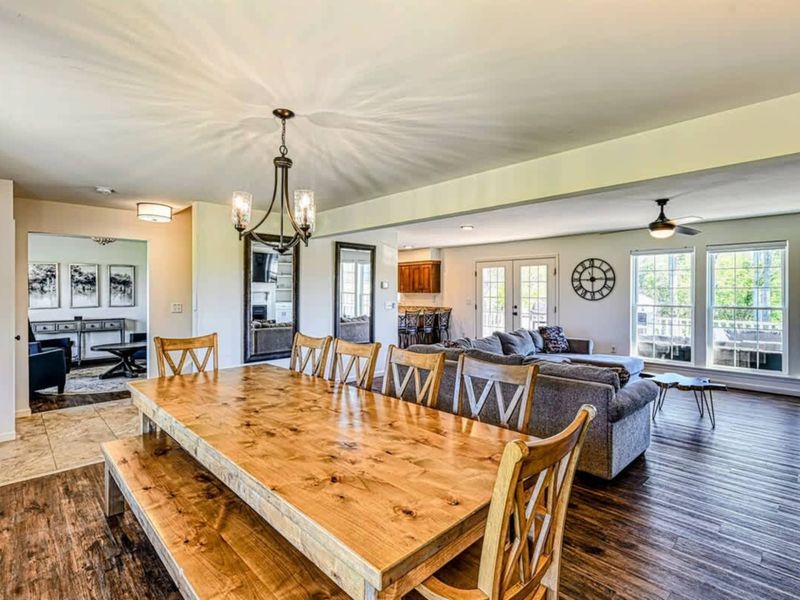 Dining Room - A wooden table sized for sixteen, the kitchen one turn away, lake views through every window.