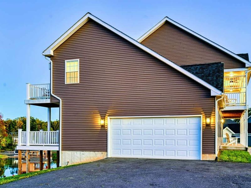Garage Side - Two-car garage, EV charger, balcony above for upstairs guests.