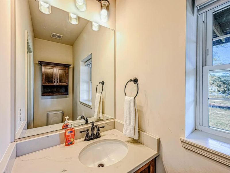 Half Bath - Single vanity, modern fixtures, natural light from a window.