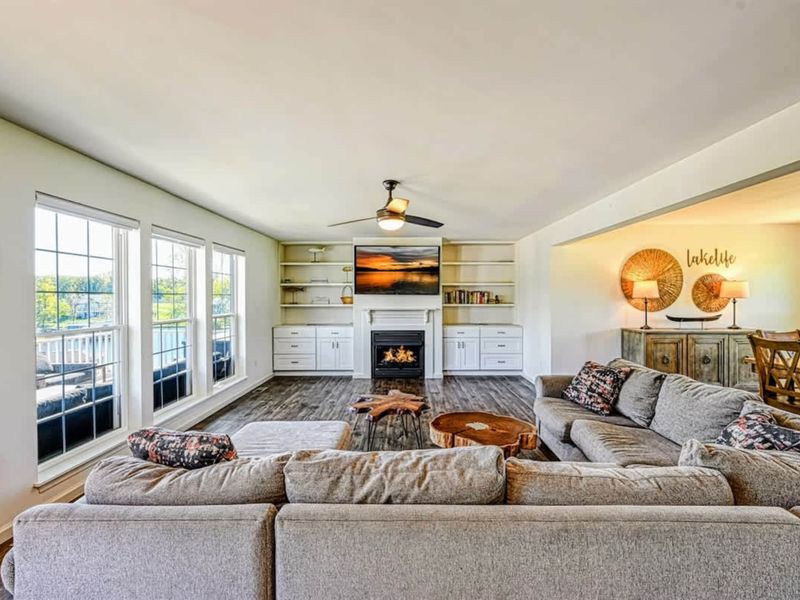 Great Room - Vaulted ceiling, corner sectional, and a wall of windows pulling the lake inside.