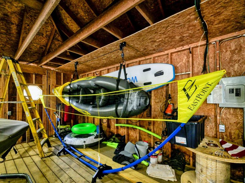 Boathouse storage area equipped with kayaks, paddleboards, and recreational gear for lake activities.