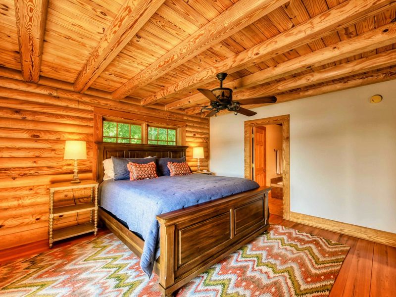 The room combines rustic charm with modern comfort, featuring wooden beams, elegant lighting, and an en suite bathroom.