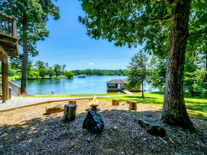 A peaceful lakeside fire pit area surrounded by nature provides the perfect setting for cozy evenings and scenic views.