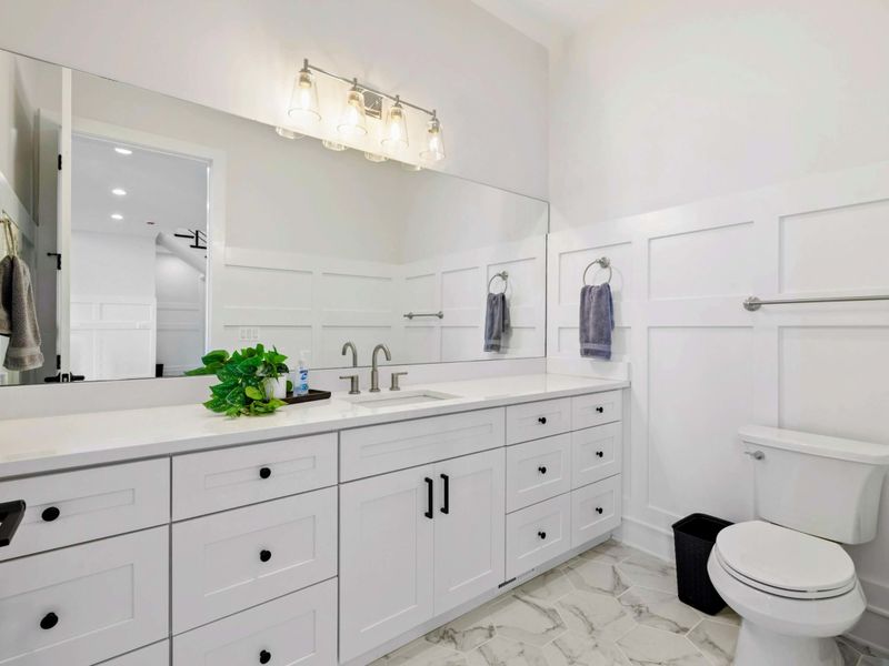 Half Bath - Single vanity, brushed-nickel fixtures, board-and-batten paneling. Convenient powder room off the main level.