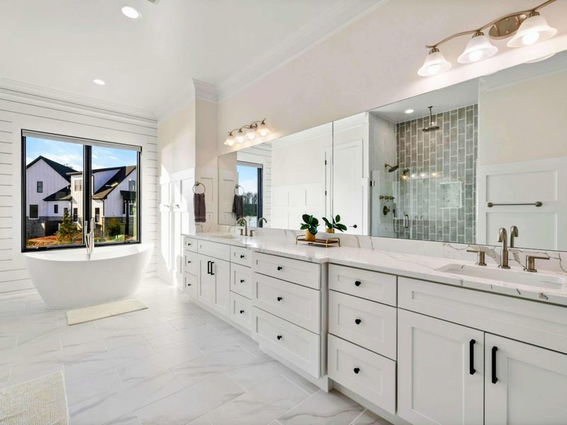 This spacious primary bedroom features a comfortable bed, a private seating area, access to a balcony with stunning lake views, and an en suite bathroom for added convenience.