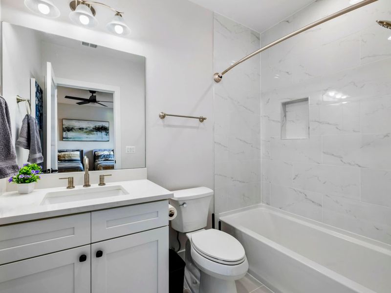 Full Bath - Single vanity, deep tub-shower combo, marble-look tile. Quiet space for getting ready before heading out.