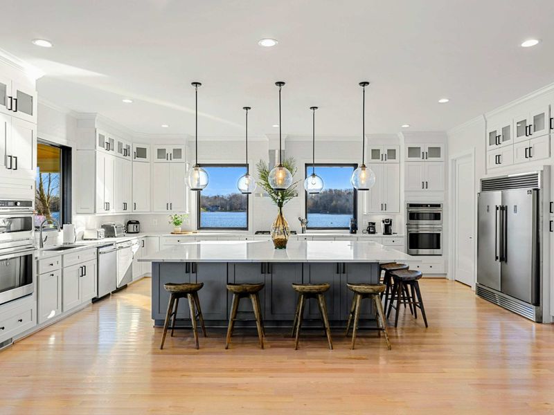 Kitchen - Quartz island with seating for four, gas cooktop, double oven, and a window that brings the lake right into the cooking.