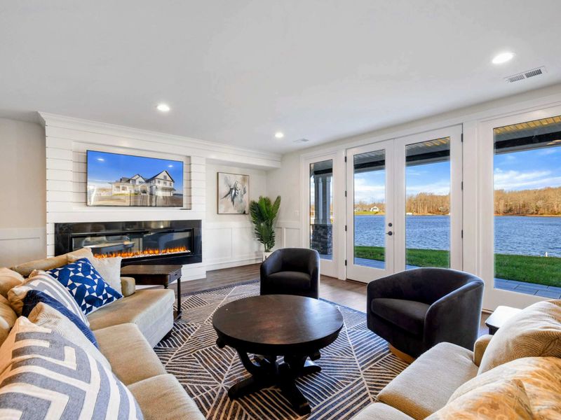 Lower Lounge - Open family room with sectional, electric fireplace, and French doors that lead straight to the lake-level patio.