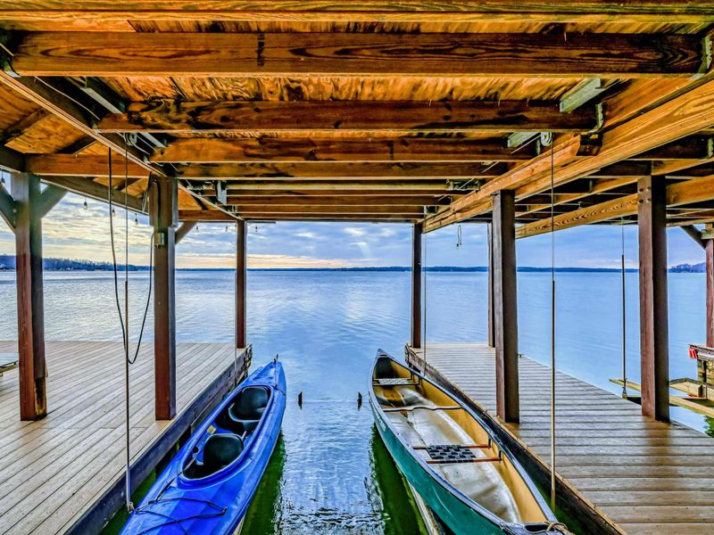 Covered boathouse with kayaks and a canoe, offering direct access to peaceful lake adventures.