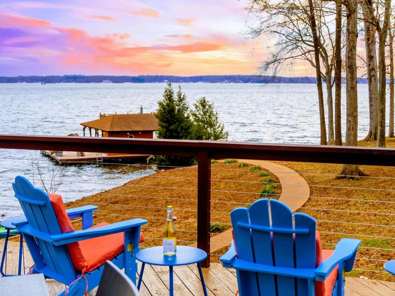 Relax in vibrant Adirondack chairs on the deck while soaking in the stunning lake views and colorful sunsets, creating the perfect serene retreat.