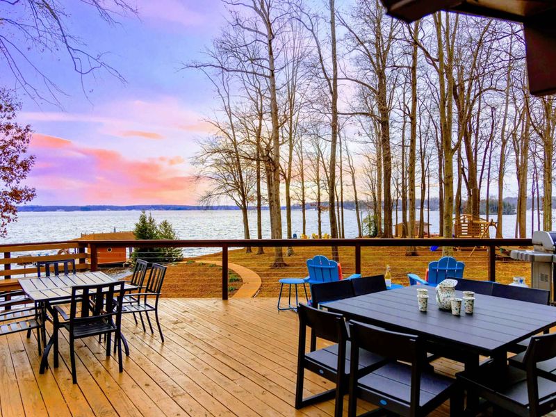This spacious deck offers stunning lake views, multiple dining areas, and a convenient grill station, perfect for outdoor gatherings and enjoying breathtaking sunsets.