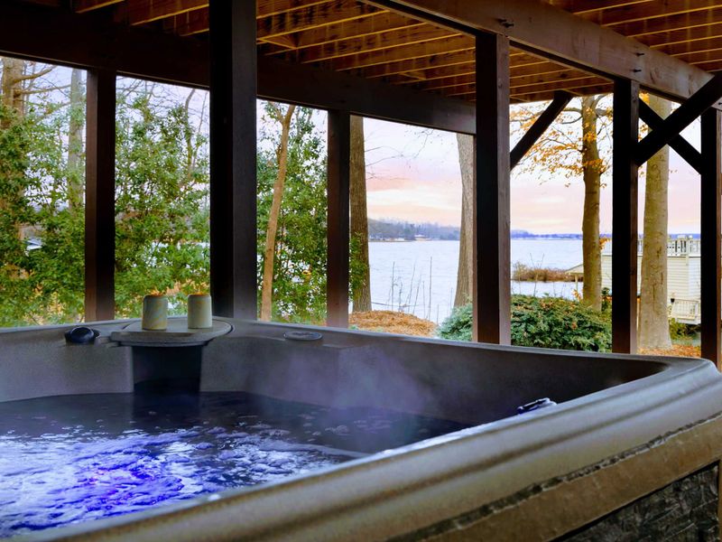 This private hot tub, nestled under the deck, offers a tranquil retreat with warm, bubbling water and stunning lake views, perfect for unwinding at the end of the day.
