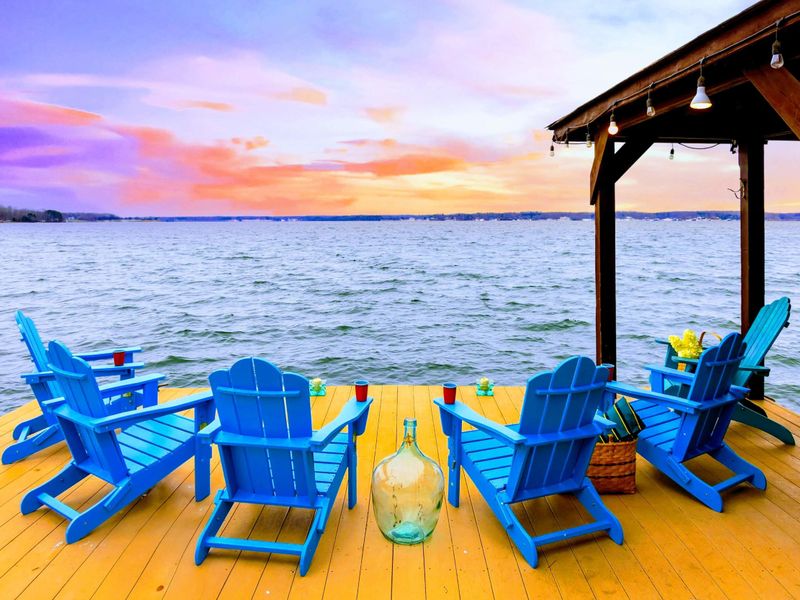 The boat dock features stunning sunset views over the water, complete with comfortable Adirondack chairs for the perfect lakeside retreat.