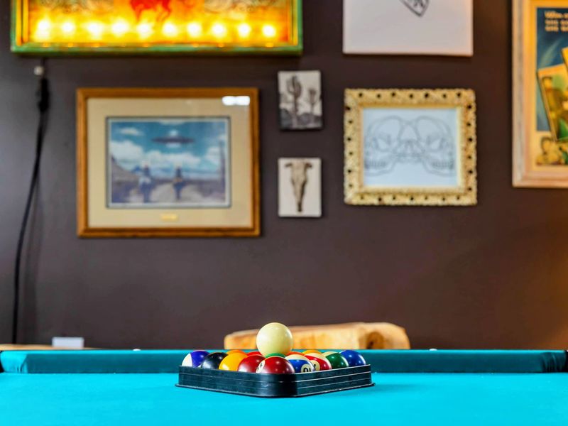 The Game Room’s pool table invites friendly competition, set against a backdrop of western-inspired wall art that adds a unique character to this entertaining space.