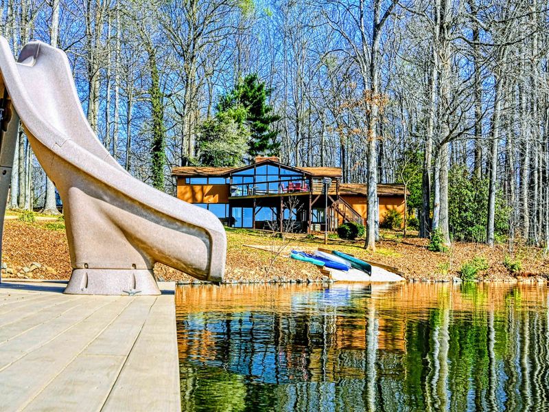 Lakefront boathouse with a water slide, kayak, and easy access to fun activities on the water.