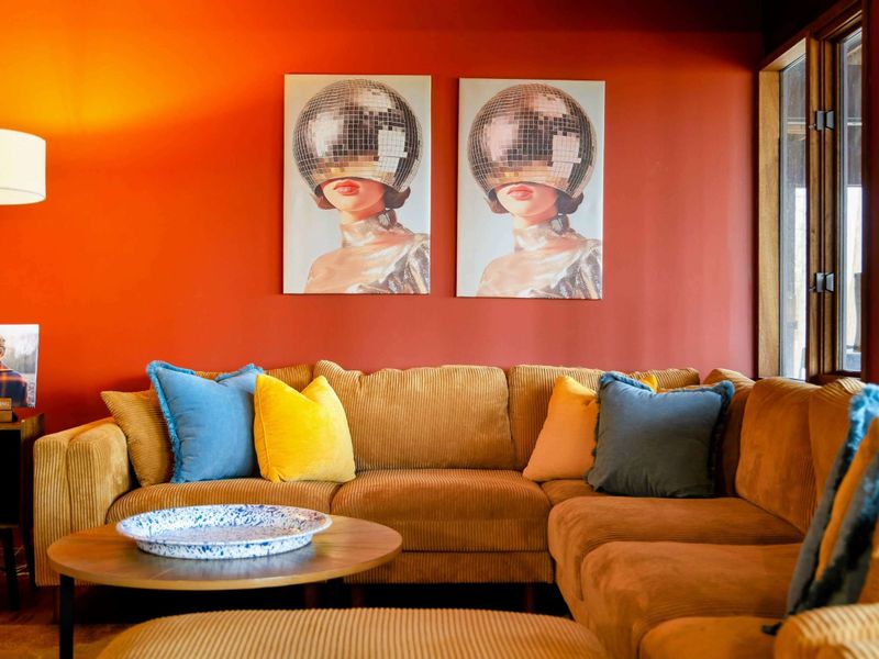 A stylish seating area featuring bold artwork and a cozy sectional, perfect for unwinding in a vibrant and inviting atmosphere.