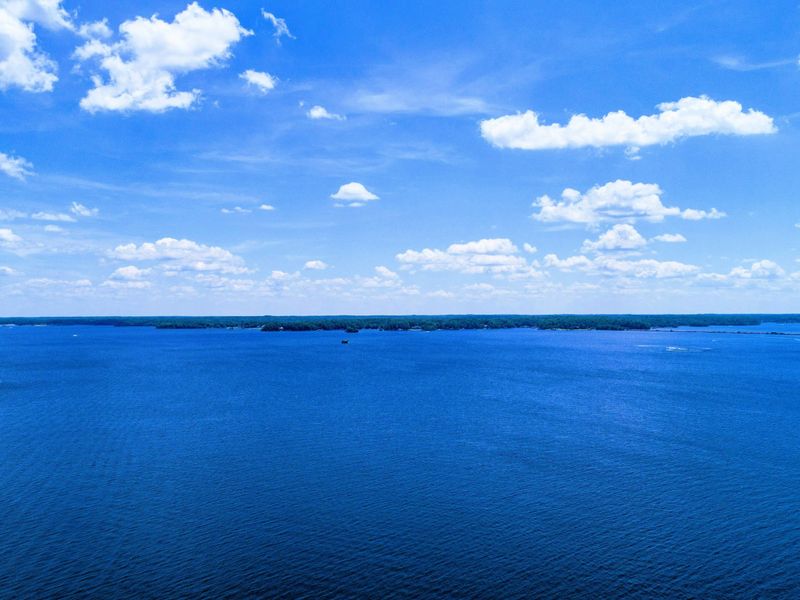 Expansive lake view under a bright blue sky, perfect for enjoying serene and uninterrupted natural beauty.