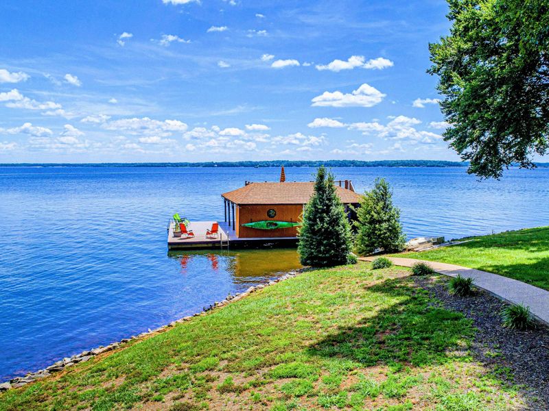 Beautiful lakefront property with a private dock, boathouse, and stunning panoramic water views.