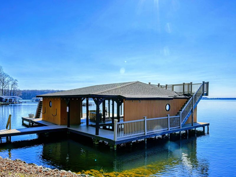 This spacious boathouse features a covered dock, sun deck, and breathtaking views, offering the perfect lakeside retreat.