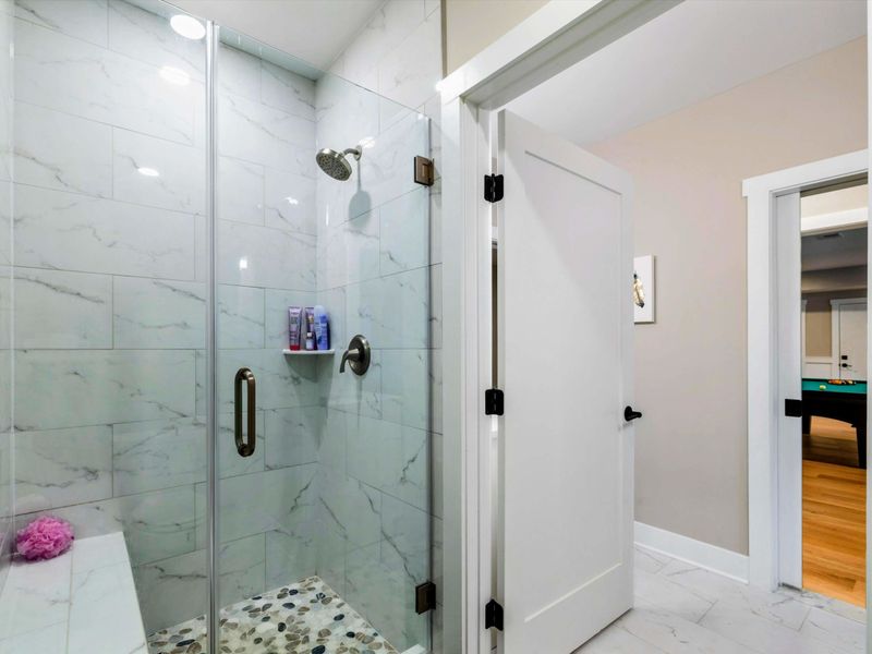 A spacious Jack and Jill bathroom featuring dual vanities, a modern walk-in shower, and convenient access to connecting bedrooms.