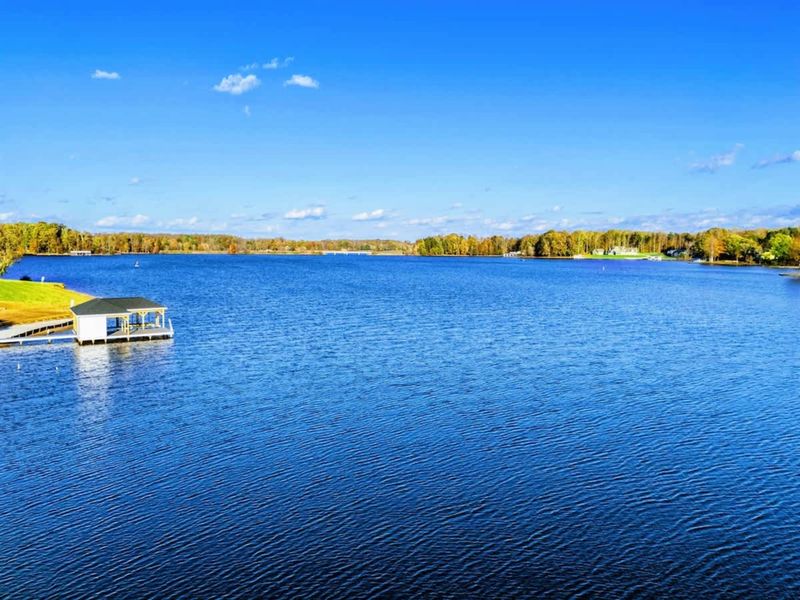 Expansive lake view with calm waters and a private dock on the shoreline.