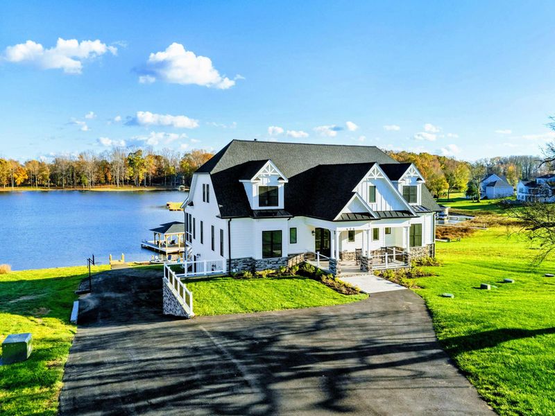 Stunning lakeside home with a modern farmhouse design, expansive front porch, and picturesque water views.