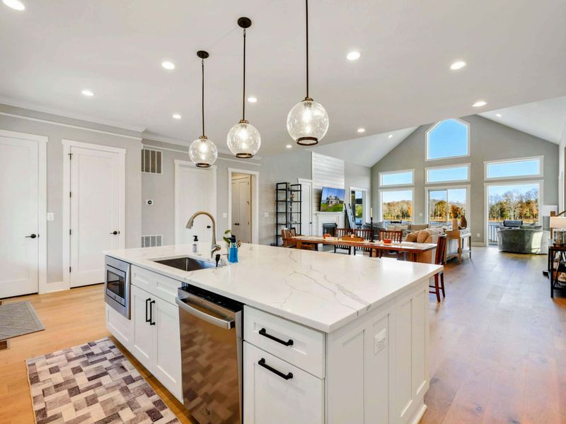Spacious open-concept kitchen and living area with vaulted ceilings, modern fixtures, and abundant natural light.