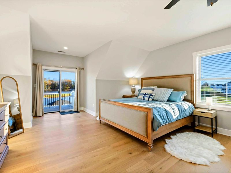 A bright and inviting bedroom with a cozy sitting area, a comfortable bed, a private balcony, and an en-suite bathroom for added convenience.