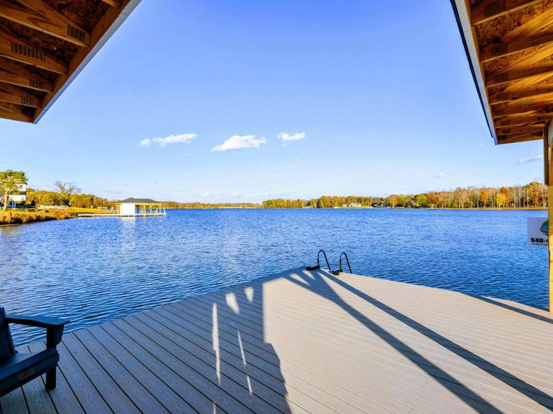 Covered dock with Adirondack chairs overlooking a serene lake, perfect for relaxing and enjoying the view.