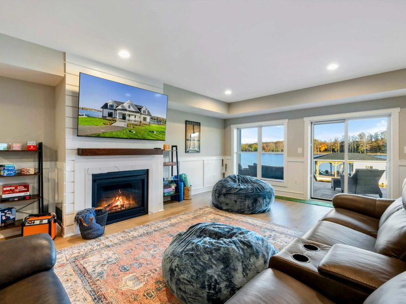 A cozy entertainment area featuring a large leather sectional, plush seating, a stylish rug, and a dining nook, seamlessly connected to a kitchenette and recreation space.