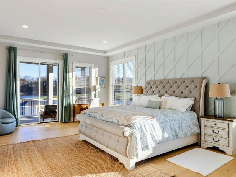 A luxurious and spacious primary bedroom with elegant furnishings, abundant natural light, a private balcony, and an en-suite bathroom.