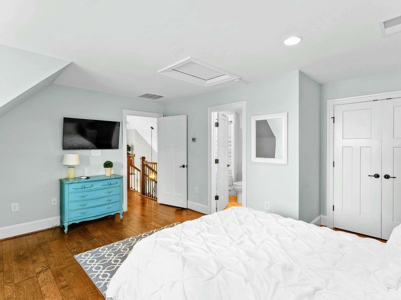 A charming bedroom with a cozy king bed, a built-in window seat, stylish decor, and an ensuite bathroom for added comfort.