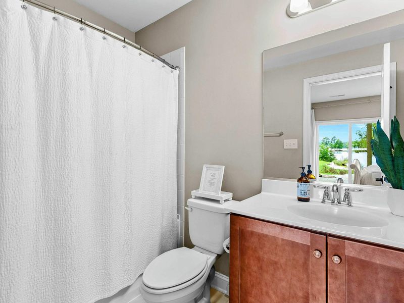 A clean and bright bathroom featuring a shower-tub combination, a sleek vanity, and modern fixtures for a comfortable stay.