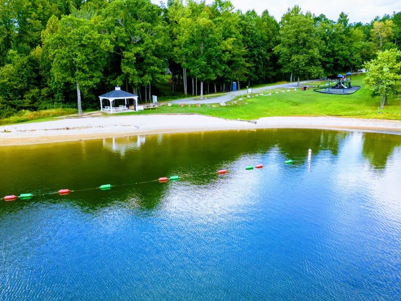 The rental includes access to The Waters community amenities, including a marina, swimming pool, tennis courts, picnic pavilions, a playground, and a sandy beach with lakefront views.