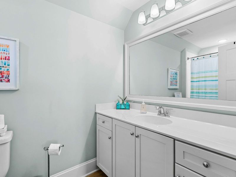 A bright and modern bathroom featuring a large vanity with ample storage, a spacious mirror, and a clean, refreshing design.