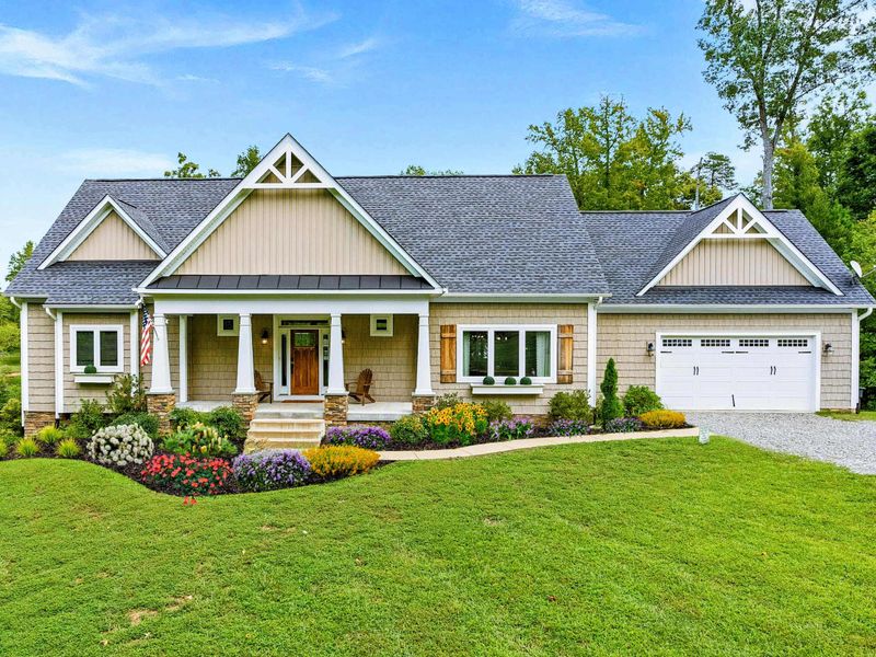 A charming and spacious home with beautiful landscaping, a welcoming front porch, and a two-car garage in a serene setting.